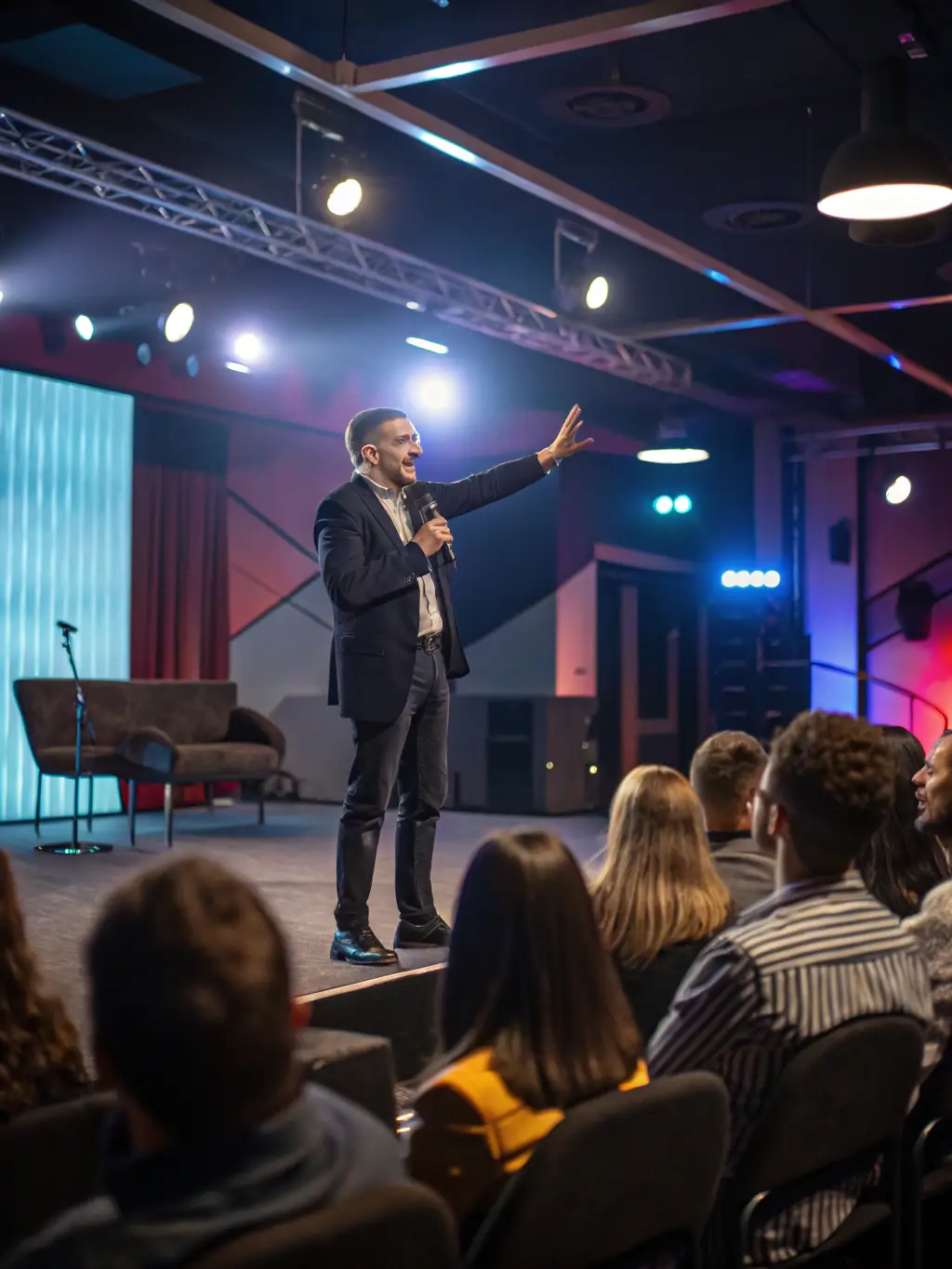 A photo of a keynote speaker passionately addressing a large audience at a SynergyUno tech conference in Johannesburg, South Africa.