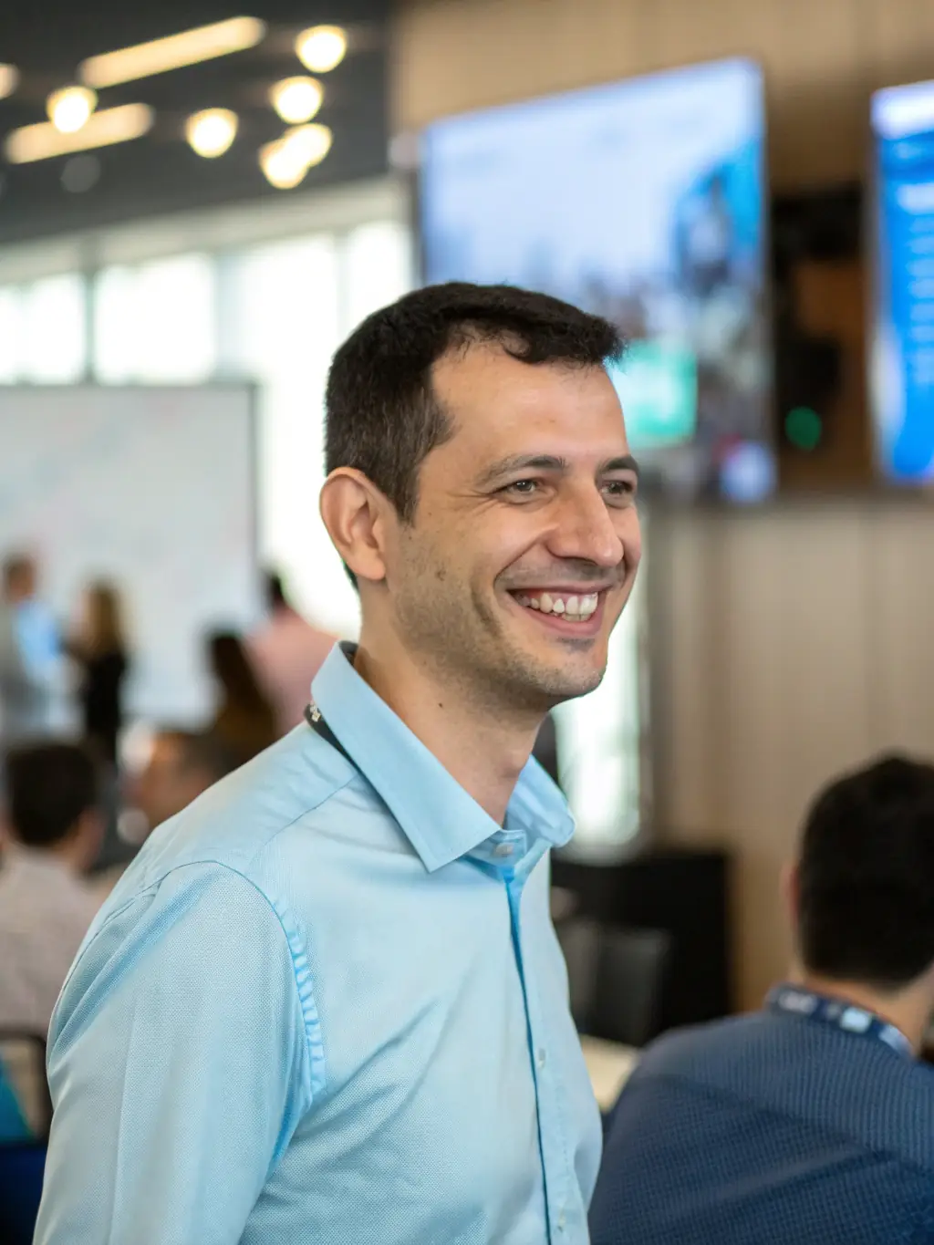 A professional headshot of Mr. Ben van der Merwe, a software development innovator, with a creative and enthusiastic expression. He is wearing a casual outfit in a tech startup environment.